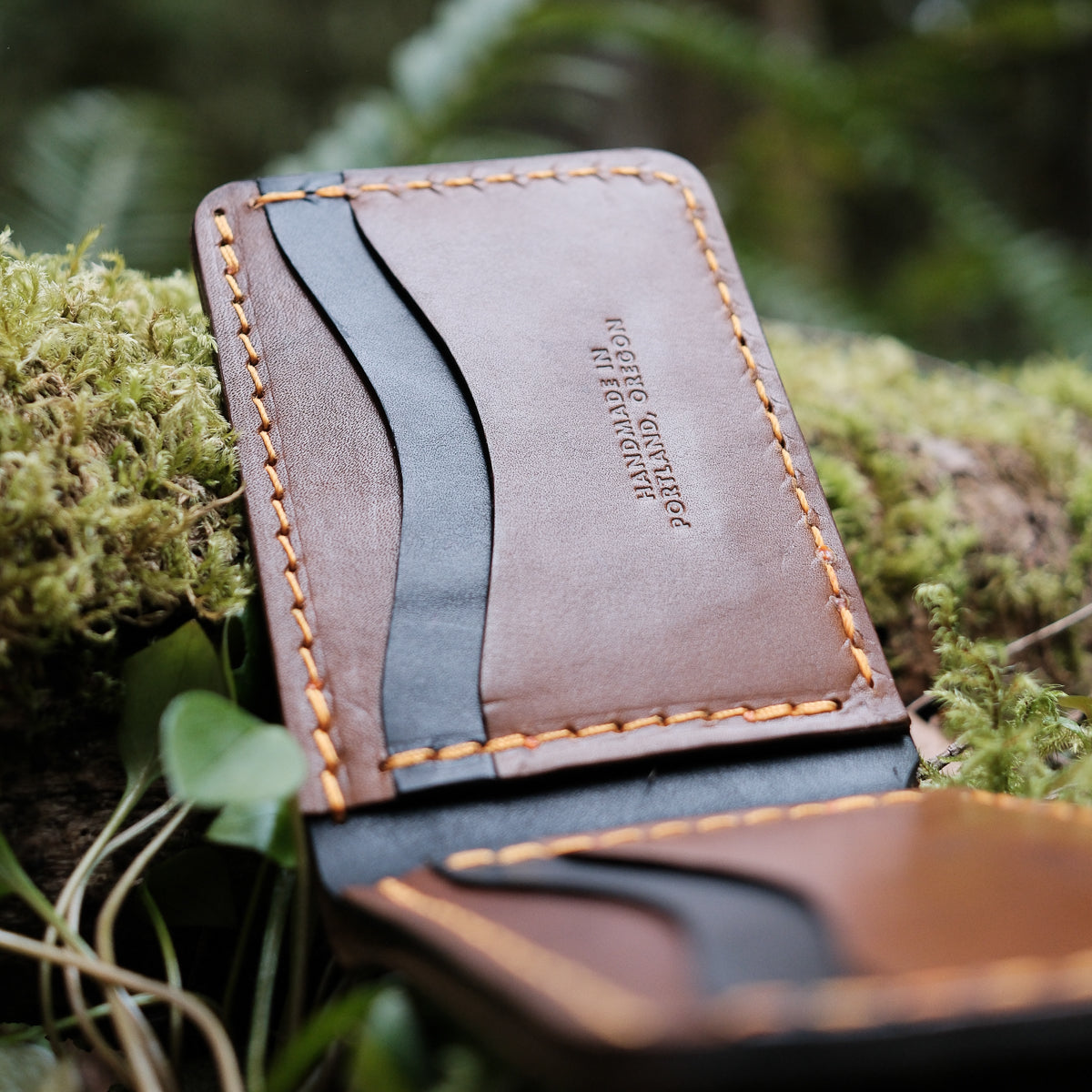 brown and black leather bifold wallet made from full grain leather